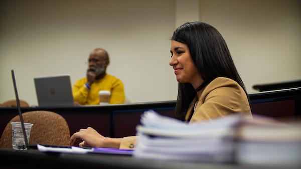 A female student looking at her laptop computer during a lecture.